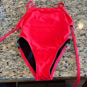 Jolyn One Piece. Tie back suit. Pink with blue and black stripes on the side.